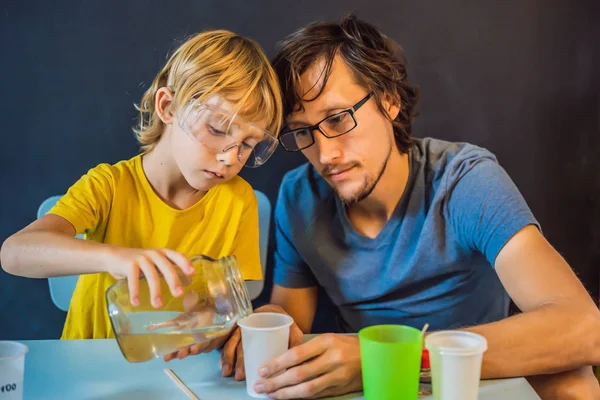 Padre e figlio conducono esperimenti chimici a casa. Bava fatta in casa — Foto Stock