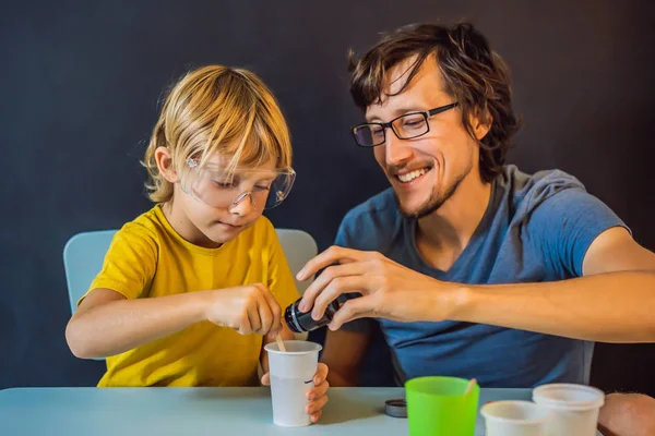 Padre e figlio conducono esperimenti chimici a casa. Bava fatta in casa — Foto Stock