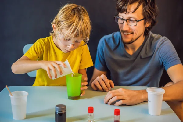 Отец и сын проводят химические эксперименты дома. Домашняя слизь — стоковое фото