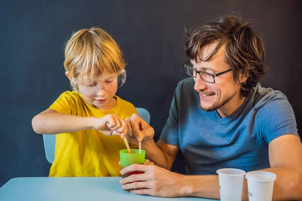 Padre e figlio conducono esperimenti chimici a casa. Bava fatta in casa. Famiglia gioca con una melma — Foto Stock