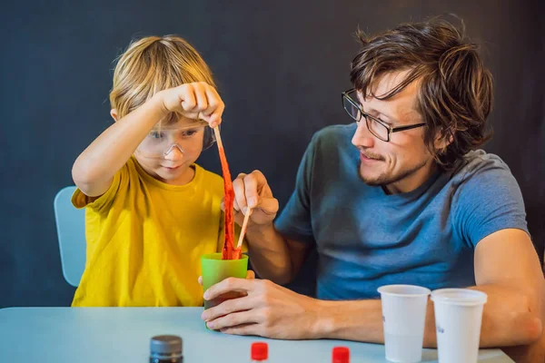 Otec a syn doma provádějí chemické experimenty. Domácí sliz. Rodina si hraje s slizem — Stock fotografie