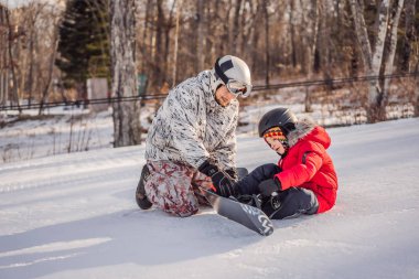 Babası oğluna snowboard öğretiyor. Kışın çocuklar için etkinlikler. Çocuklar kış sporu. Yaşam biçimi