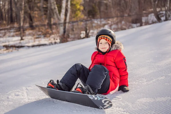 Um bonitinho de snowboard. Atividades para crianças no inverno. Desporto de inverno das crianças. Estilo de vida — Fotografia de Stock