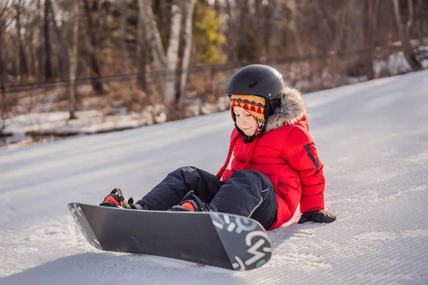 Kleiner netter Junge beim Snowboarden. Aktivitäten für Kinder im Winter. Kinderwintersport. Lebensstil — Stockfoto