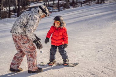 Babası oğluna snowboard öğretiyor. Kışın çocuklar için etkinlikler. Çocuklar kış sporu. Yaşam biçimi