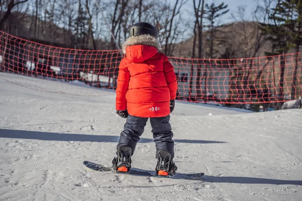 Um bonitinho de snowboard. Atividades para crianças no inverno. Desporto de inverno das crianças. Estilo de vida — Fotografia de Stock