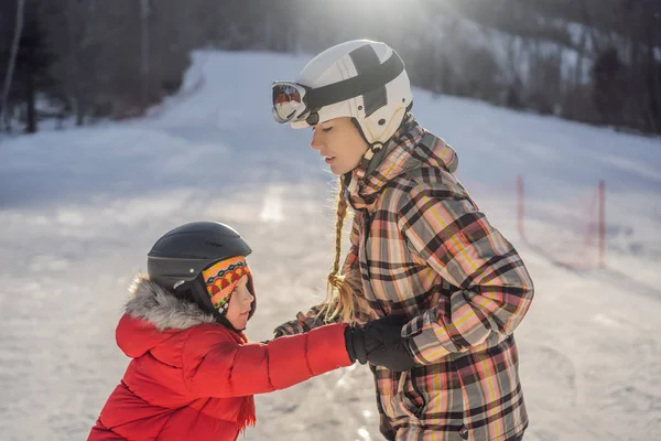 Madre enseña a su hijo snowboard. Actividades para niños en invierno. Deporte de invierno para niños. Estilo de vida — Foto de Stock