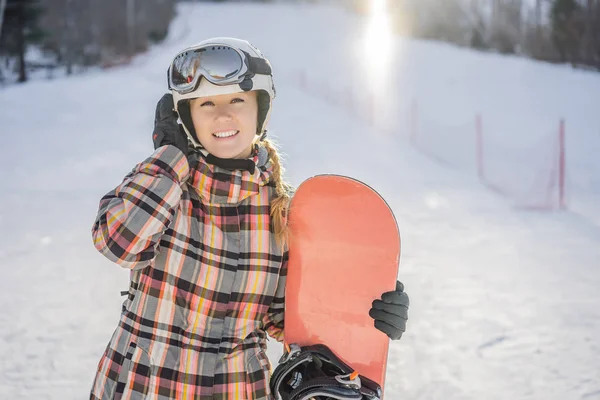 Kobieta snowboardzistka w słoneczny zimowy dzień w ośrodku narciarskim — Zdjęcie stockowe