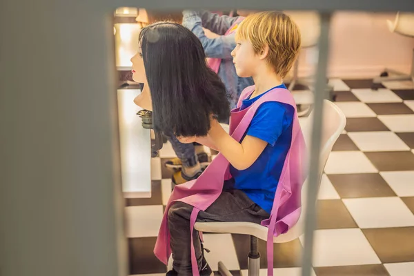 boy hairdresser, day of choice of profession, play at the hairdresser in the childrens beauty salon, hairstylist, hairdressing, barber job