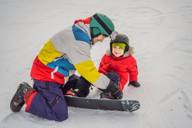 Snowboard eğitmeni bir çocuğa snowboard yapmayı öğretiyor. Kışın çocuklar için etkinlikler. Çocuklar kış sporu. Yaşam biçimi