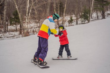 Snowboard eğitmeni bir çocuğa snowboard yapmayı öğretiyor. Kışın çocuklar için etkinlikler. Çocuklar kış sporu. Yaşam biçimi
