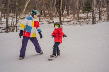 Snowboard eğitmeni bir çocuğa snowboard yapmayı öğretiyor. Kışın çocuklar için etkinlikler. Çocuklar kış sporu. Yaşam biçimi