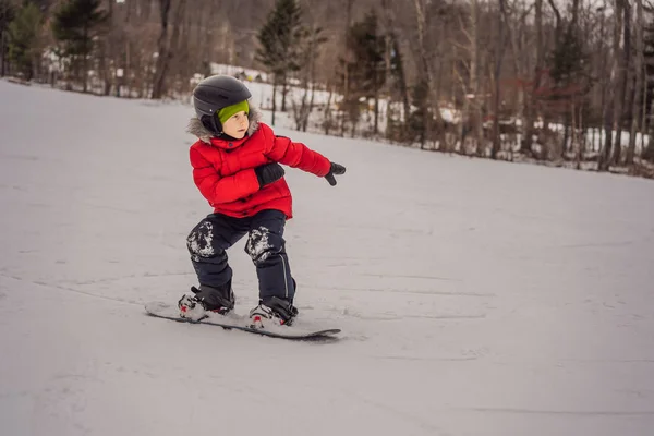 Kleiner netter Junge beim Snowboarden. Aktivitäten für Kinder im Winter. Kinderwintersport. Lebensstil — Stockfoto