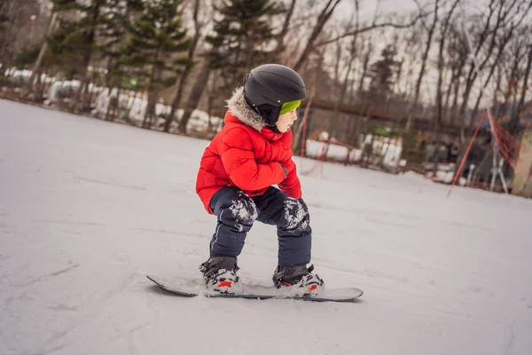 Küçük sevimli çocuk snowboard yapıyor. Kışın çocuklar için etkinlikler. Çocuklar kış sporu. Yaşam biçimi — Stok fotoğraf