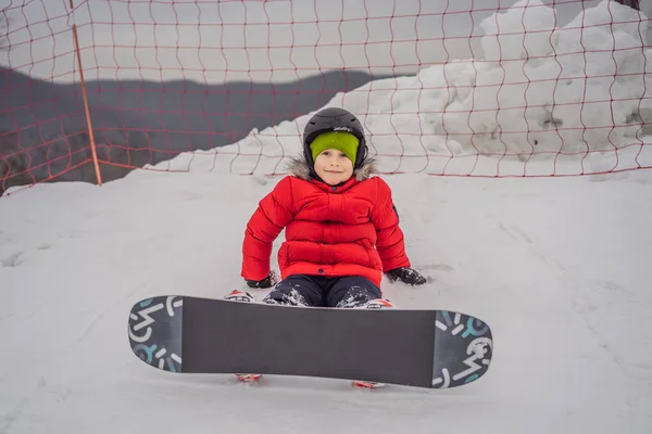 Um bonitinho de snowboard. Atividades para crianças no inverno. Desporto de inverno das crianças. Estilo de vida — Fotografia de Stock