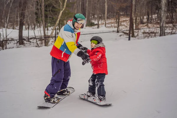 Snowboard instructor teaches a boy to snowboarding. Activities for children in winter. Childrens winter sport. Lifestyle — Stock Photo, Image