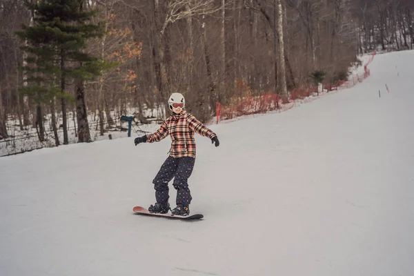 Kobieta snowboardzistka w słoneczny zimowy dzień w ośrodku narciarskim — Zdjęcie stockowe