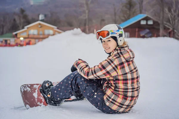 Kobieta snowboardzistka w słoneczny zimowy dzień w ośrodku narciarskim — Zdjęcie stockowe