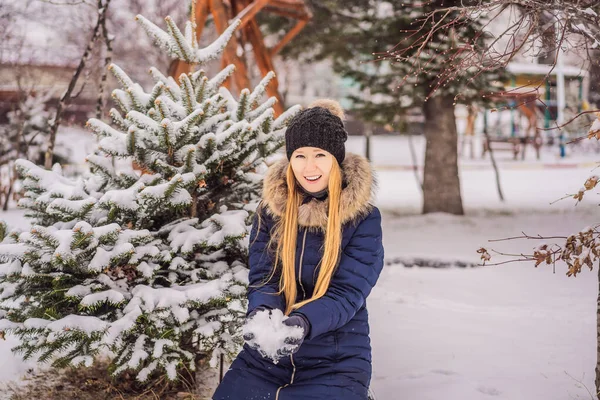 Une jeune femme profite d'une journée hivernale enneigée dans une forêt enneigée — Photo