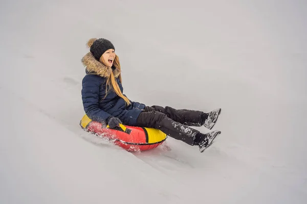 Зима, отдых, спорт, дружба и люди концепция - женщина скольжения вниз по снежным трубам — стоковое фото