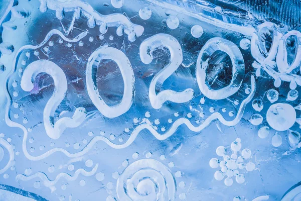 O número e o ano 2020 escrito no gelo em uma superfície de gelo — Fotografia de Stock