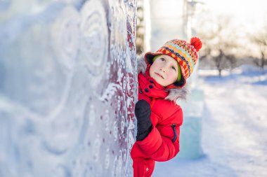 Küçük çocuk karda eğleniyor.