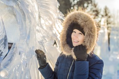 Kışın açık havada buzun arasında gülümseyen güzel bir genç kadın. Kış konsepti