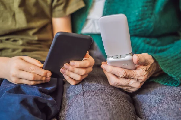 Old woman uses an old phone, boy uses a smartphone — ストック写真