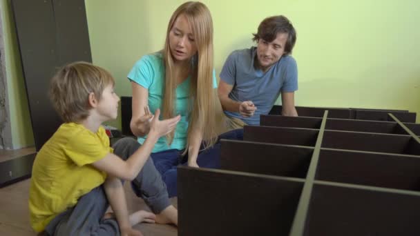 Jeune famille assembler une armoire avec des étagères — Video