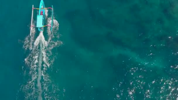 Tiro aéreo de barcos balineses tradicionais em mar aberto. Viagem ao conceito Indonésia — Vídeo de Stock