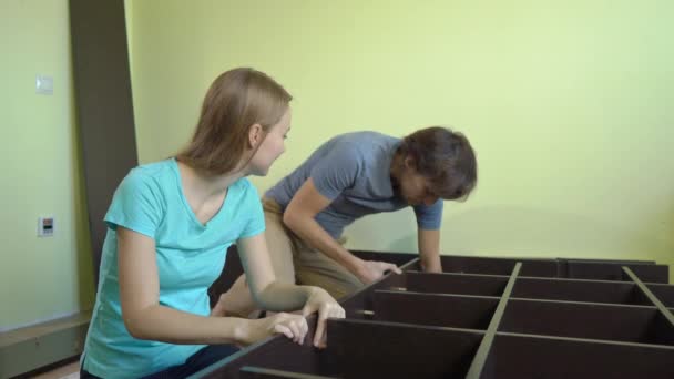 Família jovem montar um armário com prateleiras — Vídeo de Stock