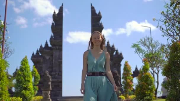 Slowmotion-skott. Ung kvinna turist besöker Brahma Vihara Arama templet på Bali ön, Indonesien. Bali resekoncept — Stockvideo