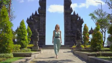 Yavaş çekim yap. Genç kadın turist Endonezya 'nın Bali adasındaki Brahma Vihara Arama tapınağını ziyaret ediyor. Bali Seyahat Konsepti