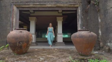 Yavaş çekim yap. Genç bayan turist Bedugul 'daki terk edilmiş ve gizemli oteli ziyaret ediyor. Endonezya, Bali Adası. Bali Seyahat Konsepti