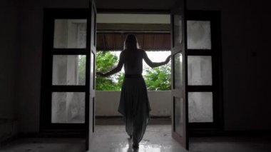 Yavaş çekim yap. Genç bayan turist Bedugul 'daki terk edilmiş ve gizemli oteli ziyaret ediyor. Endonezya, Bali Adası. Bali Seyahat Konsepti
