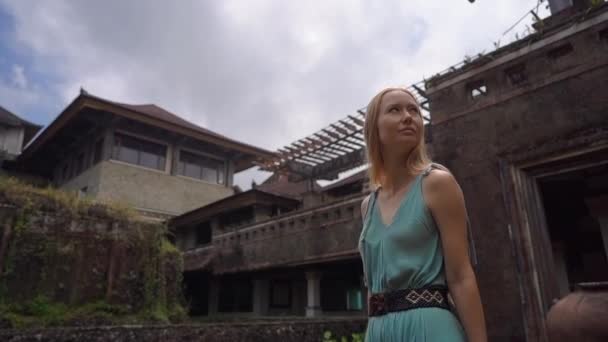 Slowmotion shot. Young woman tourist visits the abandoned and mysterious hotel in Bedugul. Indonesia, Bali Island. Bali Travel Concept — 비디오