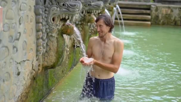 Young man tourist visits the famous Banjar Hot Springs on the Bali island. Bali Travel Concept. Slowmotion shot — 비디오