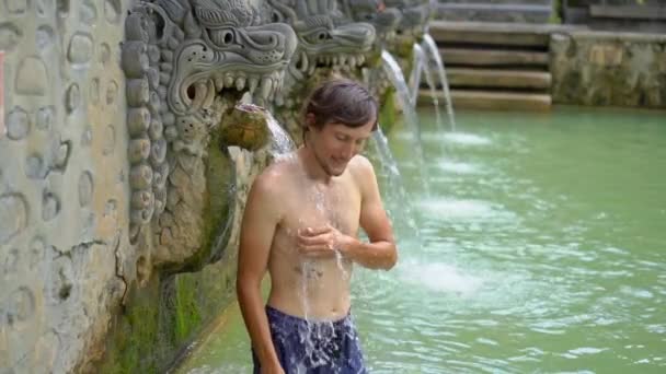 Young man tourist visits the famous Banjar Hot Springs on the Bali island. Bali Travel Concept. Slowmotion shot — Stock Video