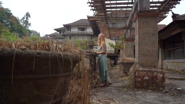 Lassított felvétel. A fiatal turista nők meglátogatják Bedugul elhagyatott és titokzatos szállodáját. Indonézia, Bali sziget. Bali utazási koncepció — Stock videók