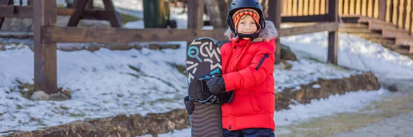 작고 귀여운 소년이 스노보드를 탈준비가 되었습니다. 겨울에는 아이들을 위한 활동을 한다. 아이들의 겨울 스포츠. 오래 전의 생활 방식 — 스톡 사진