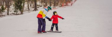 Snowboard eğitmeni bir çocuğa snowboard yapmayı öğretiyor. Kışın çocuklar için etkinlikler. Çocuklar kış sporu. HAYAT BANNER, BÖLÜM