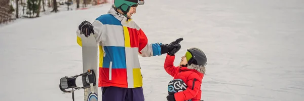 Instructor de snowboard enseña a un niño a hacer snowboard. Actividades para niños en invierno. Deporte de invierno para niños. Estilo de vida BANNER, FORMATO LARGO — Foto de Stock