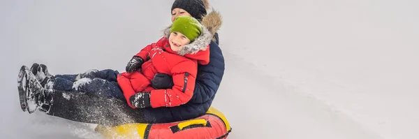 Mom son ride on an inflatable winter sled tubing. Winter fun for the whole family BANNER, LONG FORMAT — 스톡 사진