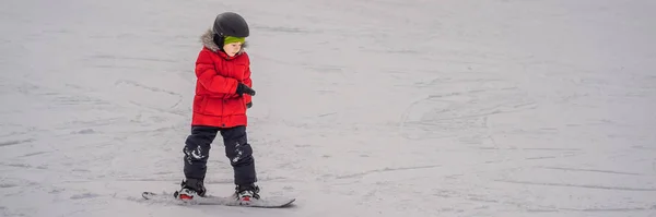 Pequeño niño lindo snowboard. Actividades para niños en invierno. Deporte de invierno para niños. Estilo de vida BANNER, FORMATO LARGO —  Fotos de Stock