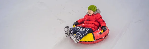 Kinder haben Spaß auf der Schneekanone. Junge reitet auf einem Schlauch. Winterspaß für Kinder Banner, Langformat — Stockfoto