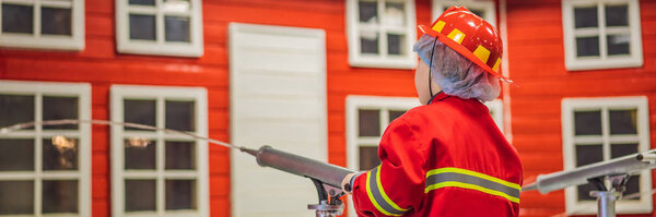 Expressive cute toddler with fireman outfit playing fireman BANNER, LONG FORMAT