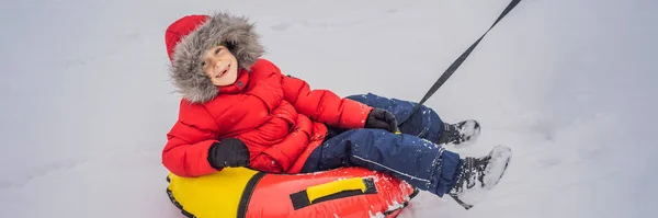 Kinder haben Spaß auf der Schneekanone. Junge reitet auf einem Schlauch. Winterspaß für Kinder Banner, Langformat — Stockfoto