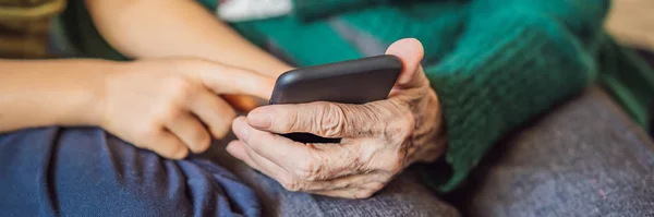 Бабушка и внук смотрят на смартфон BANNER, LONG FORMAT — стоковое фото