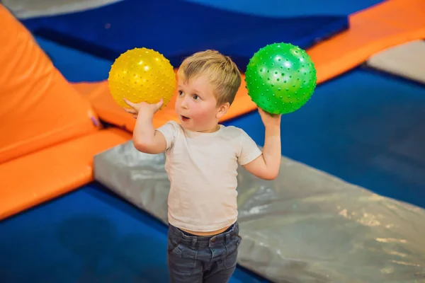 Мальчик с мячом на батутах — стоковое фото