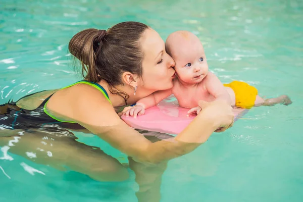 Schöne Mutter bringt süße Baby-Mädchen bei, wie man in einem Schwimmbad schwimmt. Kind vergnügt sich mit Mama im Wasser — Stockfoto